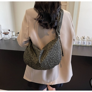 Détail du sac hobo montrant l'imprimé léopard et la toile robuste sur le mannequin
