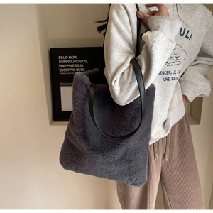 Détail du sac cabas en peluche gris foncé avec anses en cuir noir et texture fausse fourrure