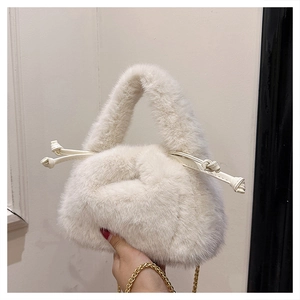 Detailed macro view of the fluffy white faux fur texture and golden metal chain strap