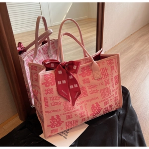 Detail of pink wedding tote bag with red Double Happiness prints and a silk bow decoration