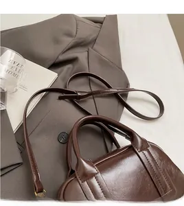 Dettaglio della tracolla lunga regolabile sulla borsa Boston in pelle marrone scuro