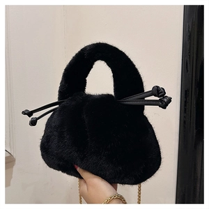 Detailed macro shot showing the soft black faux fur texture and gold chain on the bag