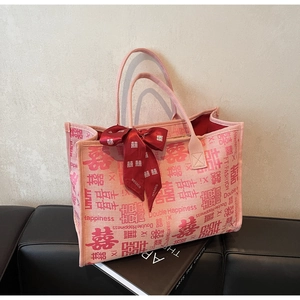 Detail of pink canvas tote bag featuring traditional Double Happiness patterns and red bow