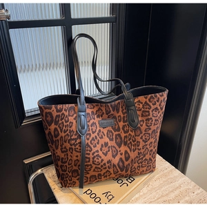Detailed view of leopard print tote bag with black straps and reinforced stitching detail