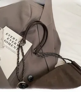 Gros plan de la chaîne en métal vintage et de la bandoulière en cuir du sac marron