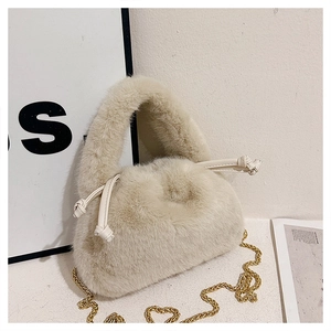 Detailed close-up of cream faux fur bucket bag featuring soft texture and gold chain strap