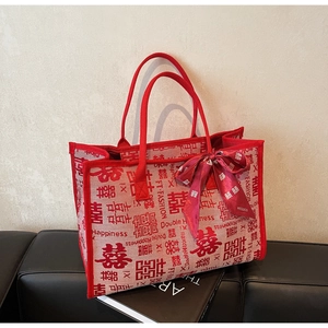 Macro shot of red wedding tote bag with double happiness print on a leather bench