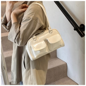 Vue latérale du sac à bandoulière crème brillant avec deux poches à rabat utilitaires