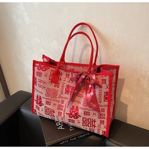 Detail of red wedding tote bag with double happiness pattern and satin ribbon bow decoration