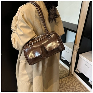 Détail du sac à main en cuir PU marron brillant avec poches à rabat et zips argentés