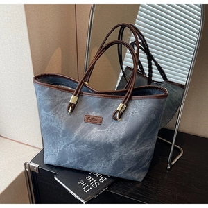 Detail of blue marble pattern tote bag with leather straps and Fashion label