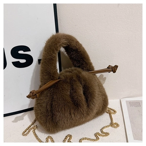 Detail of dark brown plush bucket bag with golden chain strap and soft faux fur texture