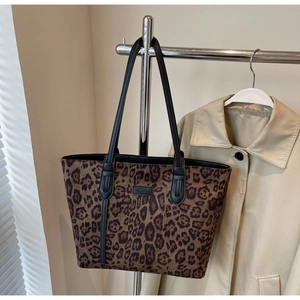 Close-up of leopard print tote bag with durable shoulder straps and brand leather patch