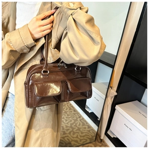 Détail du sac à main en cuir marron foncé brillant avec poches avant et fermeture éclair