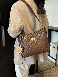 Sac seau matelassé marron foncé avec fermoir doré et pendentif feuille au style chic