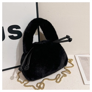 Detail of plush black handbag showing soft faux fur texture and gold chain strap