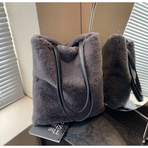 Détail du cabas en fausse fourrure gris foncé avec anses en cuir noir et texture douce