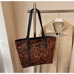 Detailed shot of leopard print tote bag hanging with beige trench coat background