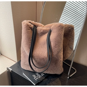 Détail de la texture en fausse fourrure douce et des anses en cuir noir sur le sac