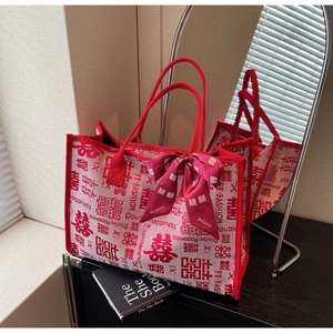 Detail of red wedding tote bag with double happiness pattern and velvet bow decoration