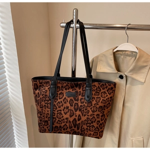 Detailed close-up of leopard print tote bag with black leather straps and brand logo