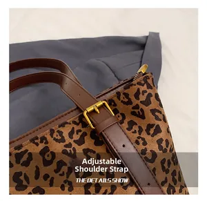 Detail showing the adjustable leather shoulder strap and leopard print faux fur texture
