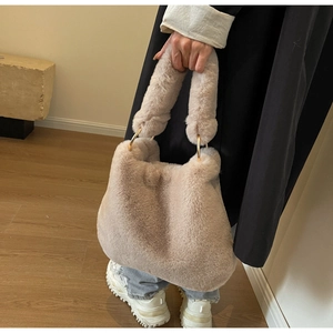 Détail du sac à main en fausse fourrure avec anneaux dorés et poignée souple