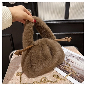 Detailed view of brown faux fur bucket bag with plush handle and gold chain strap