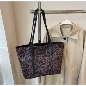 Detailed view of leopard print tote bag texture and brand tag on premium fabric