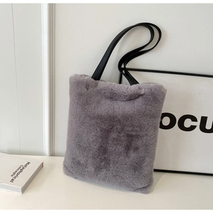 Gros plan d'un sac fourre-tout en fausse fourrure grise avec fines anses noires en cuir