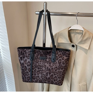 Close-up of leopard print tote bag detailing brown pattern and black leather strap