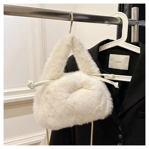 Detailed macro view of white plush faux fur texture with golden chain strap and drawstring