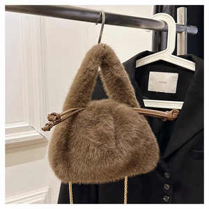 Close-up of brown plush bucket bag with faux fur texture and leather drawstring detail