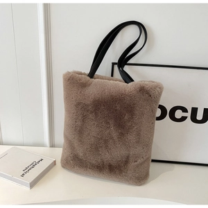 Détail d'un sac cabas en peluche taupe avec des anses noires en studio chic