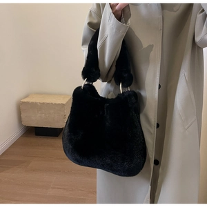 Détail du cabas en fausse fourrure noire avec anneaux dorés et texture pelucheuse