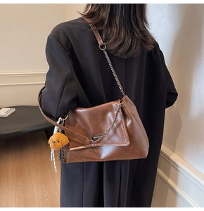 Sac à bandoulière marron en similicuir avec rabat plissé, chaîne et breloque chien