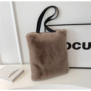 Gros plan d'un sac cabas en peluche marron avec des anses en cuir noir élégantes