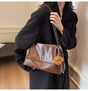 Détail du sac à bandoulière en cuir PU marron avec chaîne et pendentif ours sur modèle