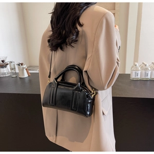 Detailansicht einer schwarzen Boston-Tasche mit glänzender Lederstruktur als Umhängetasche