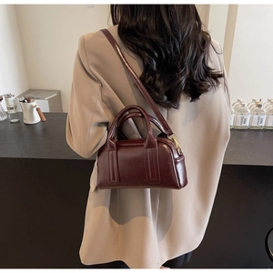 Detailansicht einer dunkelroten Vintage Boston Tasche als Schultertasche im Café