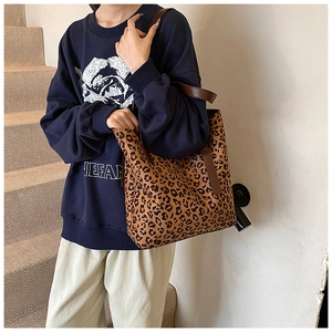 Detailed view of the large leopard print tote bag being worn over the shoulder