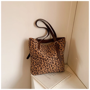 Detail shot of the dense leopard print canvas tote bag with brown leather strap design