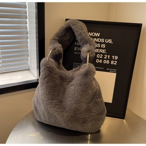 Détail d'un sac à main gris en fausse fourrure avec texture peluche et anneaux dorés