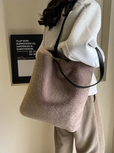 Sac cabas chic en peluche taupe avec bandoulières en cuir, porté par un mannequin