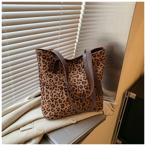 Close-up of leopard print tote bag with brown leather straps and metal brand logo