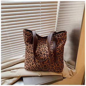 Close-up of leopard print tote bag with adjustable leather straps and golden logo