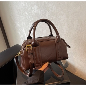 Detailansicht der dunkelbraunen Boston Tasche mit Griffen und goldenen Beschlägen