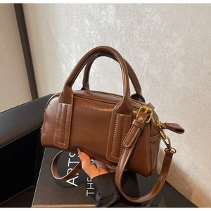Detail der dunkelbraunen Boston Bag mit Öl-Wachs-Textur und Vintage-Goldbeschlägen