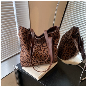Detailed view of leopard print tote bag with brown leather straps in a cozy setting