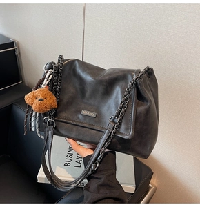 Détail du cabas en PU noir mat avec plaque métallique et pendentif ours en peluche